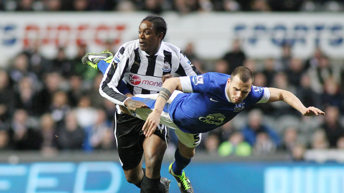 Evertons John Heitinga flyger i en närkamp med Newcastles Nile Ranger. 