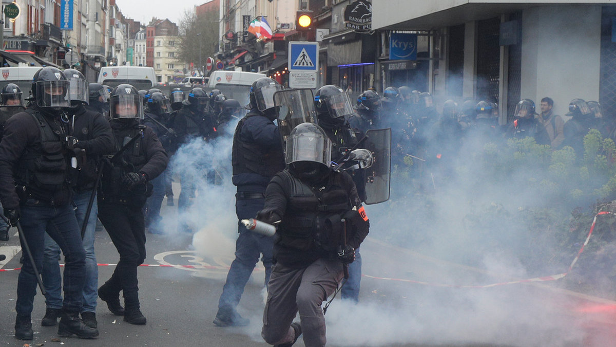 En polis förbereder sig för att kasta en tårgas under demonstrationen i Lille.