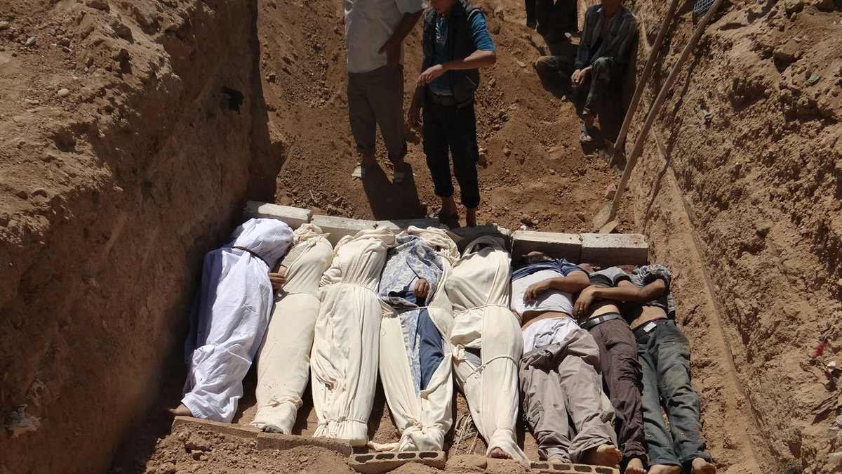 Flera kroppar begravs i en förort till Damaskus. Augusti 2013.