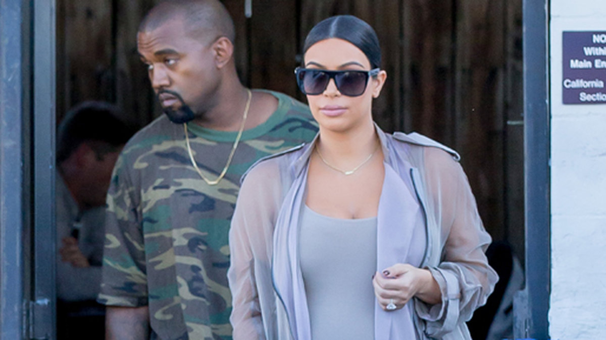 En höggravid Kim Kardashian med solstrålen Kanye West i släptåg. 