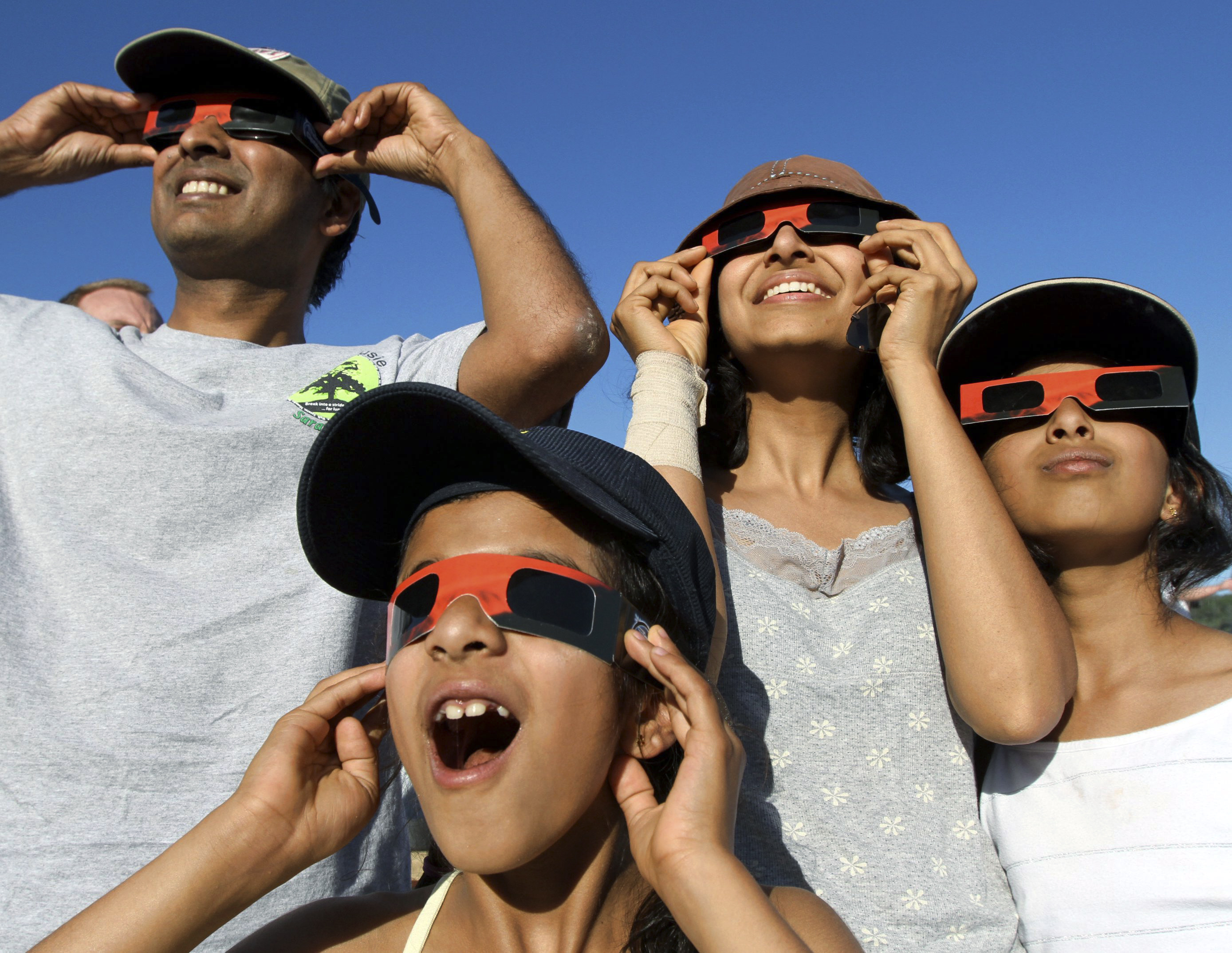 En familj sätter på sig specialbrillorna och skådar förmörkelsen i Kalifornien.
