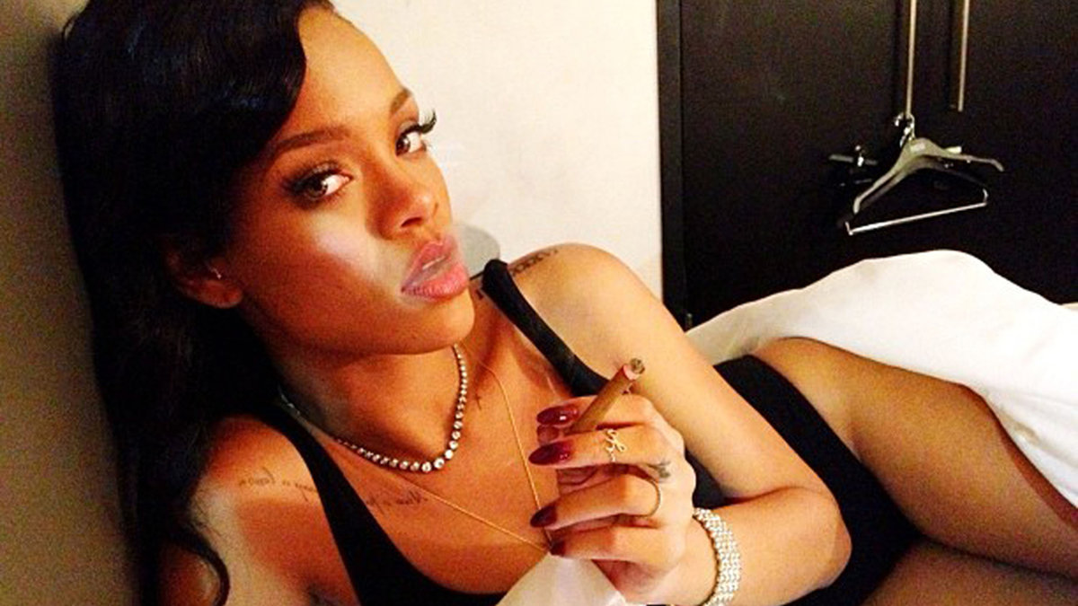 Rihanna röker en cigg i sängen. 