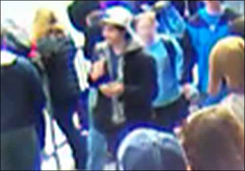Mannen i vit keps har enligt FBI setts släppa en väska vid bombplatsen.