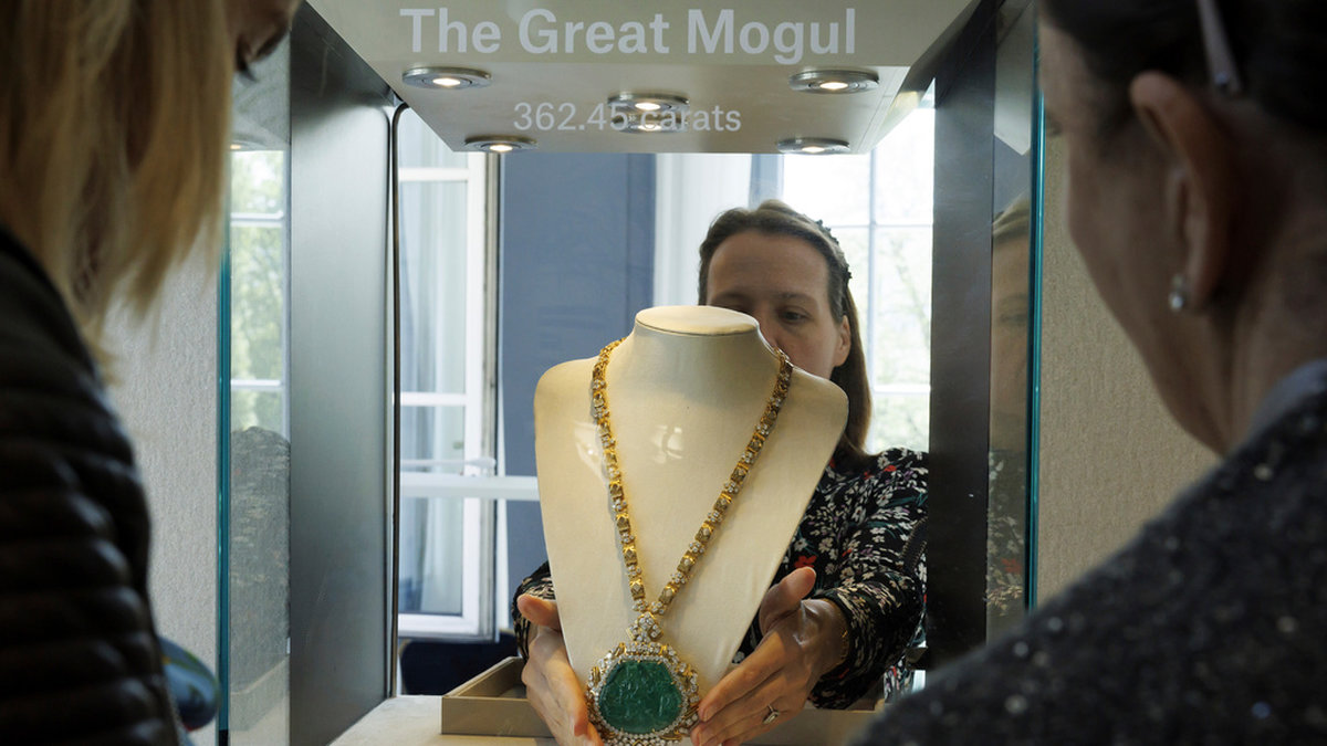 En anställd vid Christie's visar upp en smaragd med tillhörande diamanthalsband inför den kontroversiella auktionen i Genève.