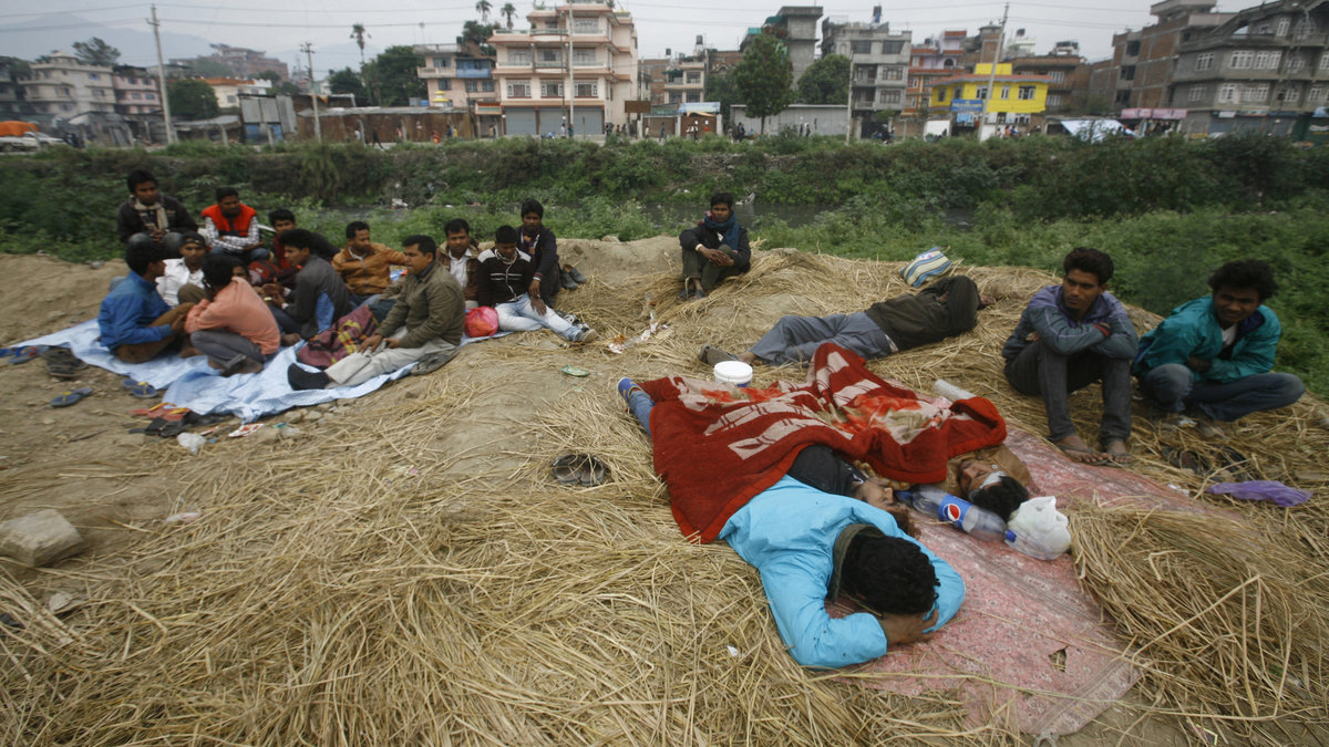 Folk vilar utomhus, dagen efter den massiva jordbävningen som ödelade regionen och förstörde mångas hem i Kathmandu.
