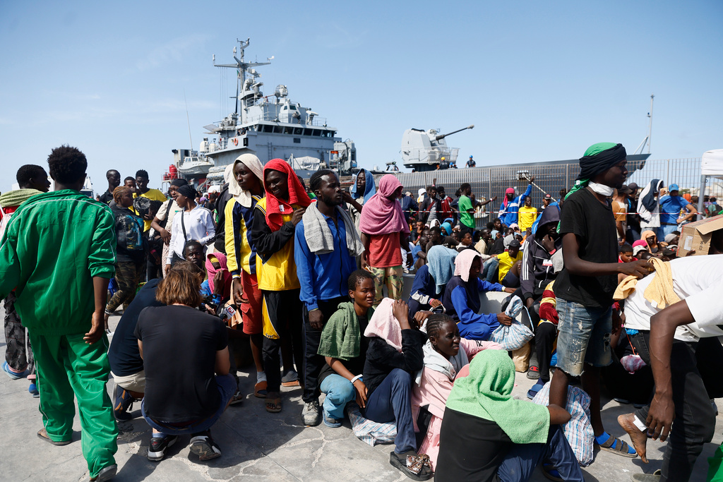 Migranter utanför Röda Korsets mottagningscenter på den italienska ön Lampedusa, en så kallad 'hot spot' där ingen är tänkt att stanna mer än tre dygn.
