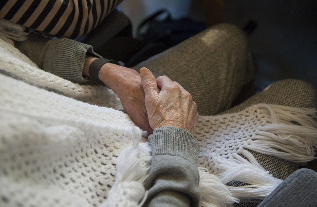 Äldre par håller varandra i händerna Äldre par håller varandra i händerna