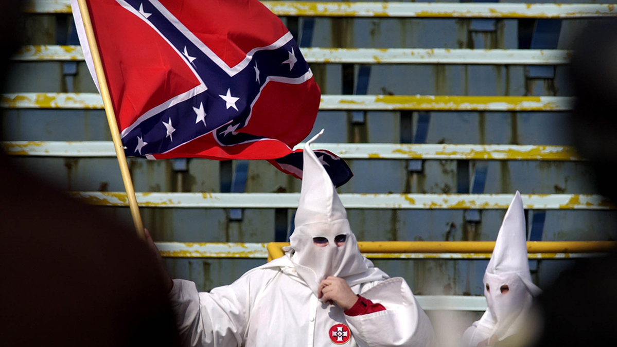 En Ku Klux Klan-medlem med en Sydstatsflagga år 2001.