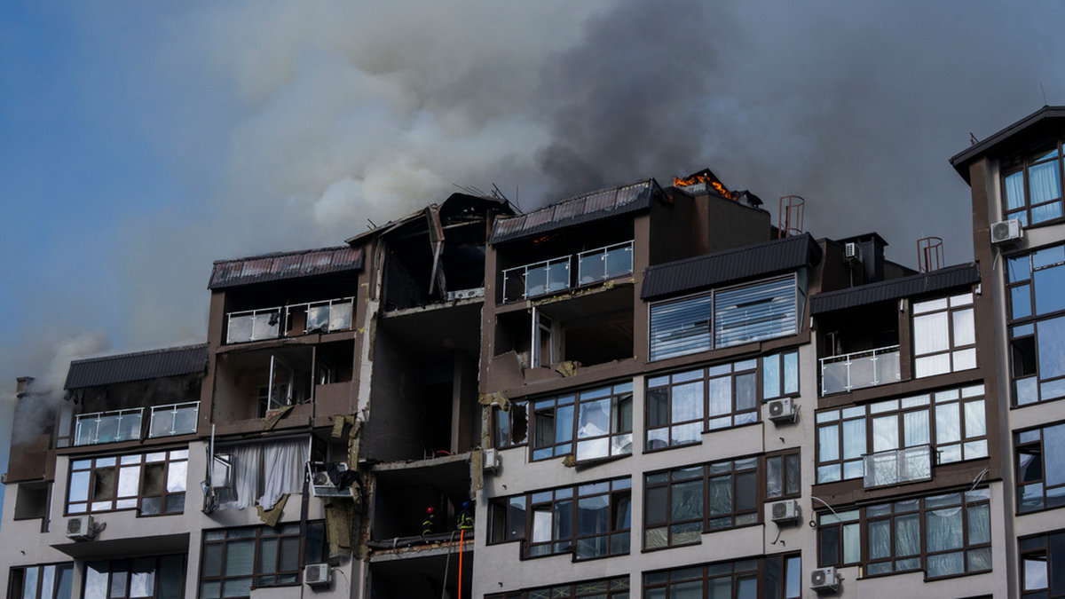 Rök stiger från ett bostadshus efter söndagsmorgonens explosioner i Kiev.