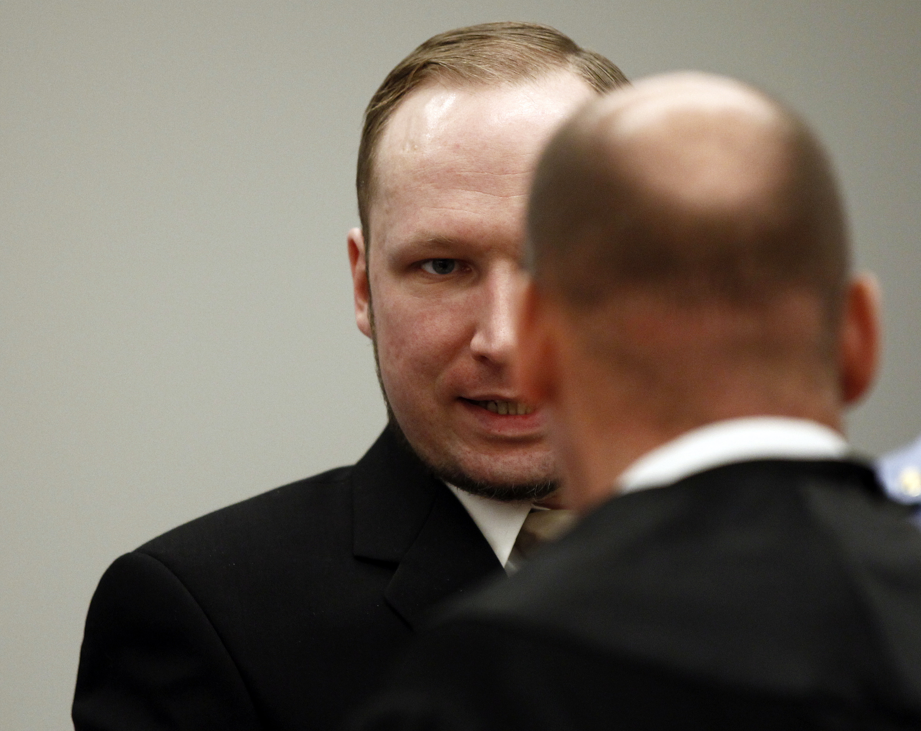 Breivik pratar med advokat Geir Lippestad under andra dagens förhandlingar. 