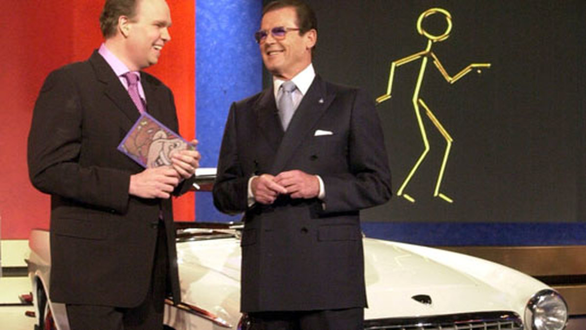 Vad har vi här då? Jo Lasse Kronér med Roger Moore som tillsammans lottar ut en likadan bil i Bingolotto i början av 2000-talet.