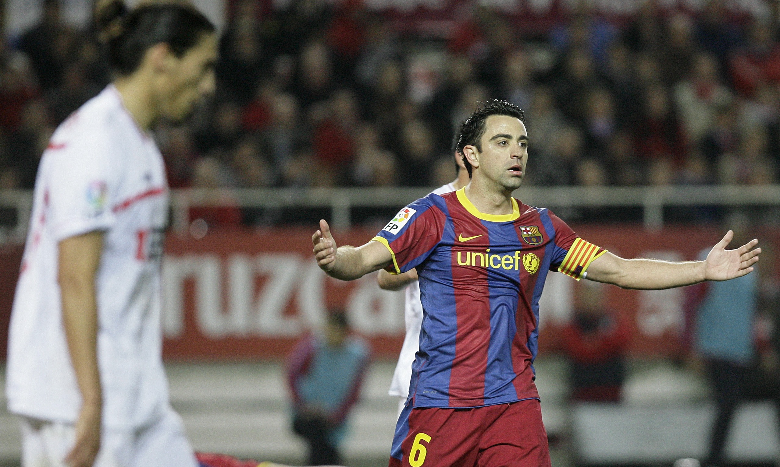 Xavi klagar på domare Perez Lasa under matchen mot Sevilla.