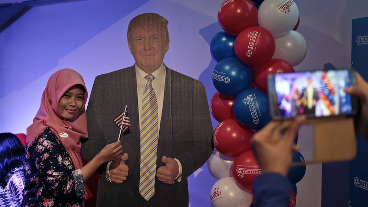 En muslimsk kvinna poserar tillsammans med en pappfigur av Donald Trump, under valvakan på USA:s ambassad i Jakarta, Indonesien.