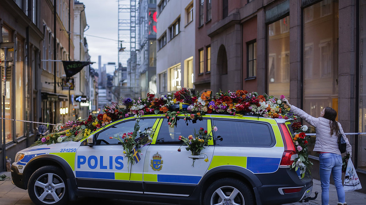 Hundratals lämnade blommor vid polisbilen Hötorget. 