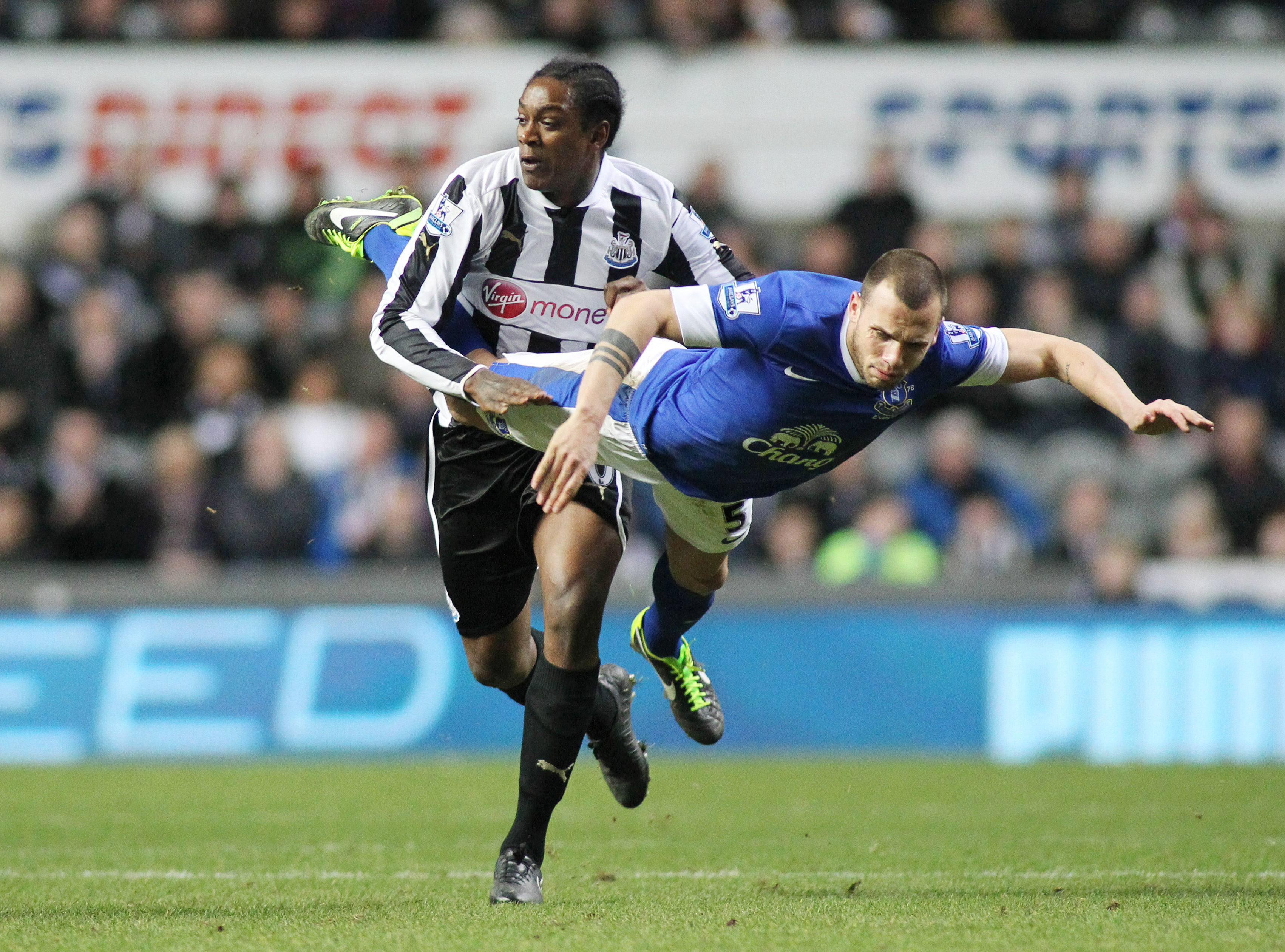 Evertons John Heitinga flyger i en närkamp med Newcastles Nile Ranger. Evertons John Heitinga flyger i en närkamp med Newcastles Nile Ranger.