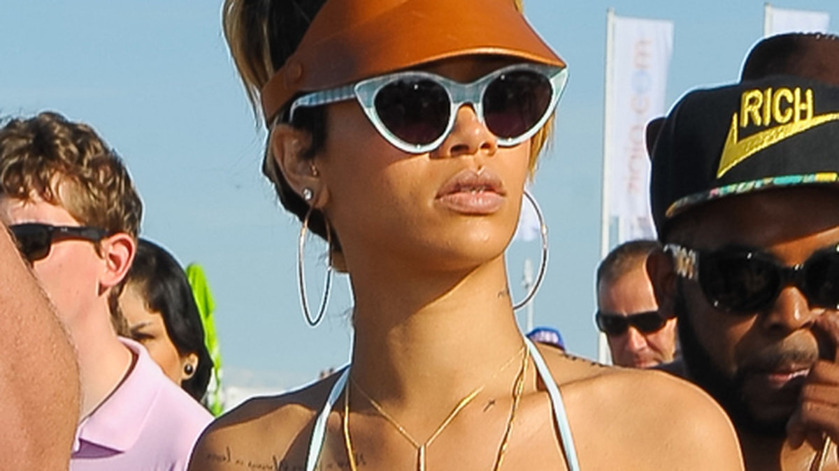 Rihanna visar sin tatuering på stranden.