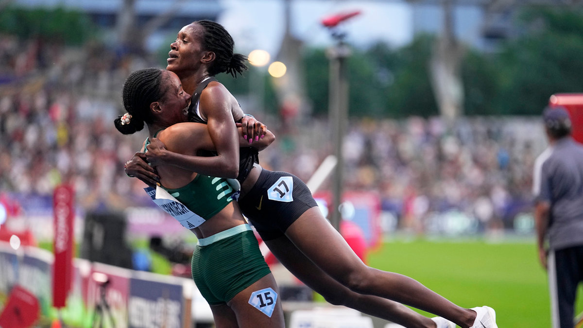 Faith Kipyegon, Kenya, hissas upp i luften av landsmaninnan Beatrice Chepkoech, till vänster, efter världsrekordet på 5 000 meter.