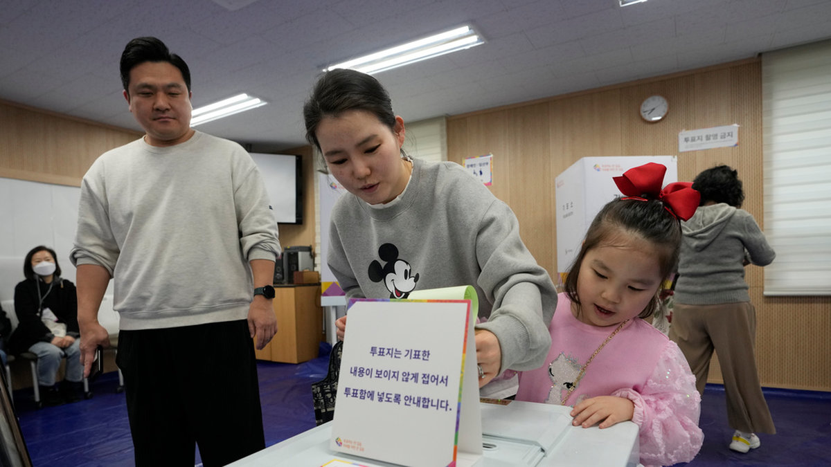 En kvinna röstar tillsammans med sin dotter i en vallokal i Sydkoreas huvudstad Seoul.