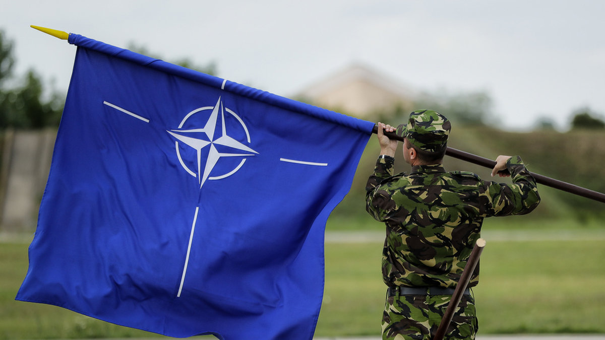 Natoflaggan, en vit kompass mot en blå bakgrund. Den blå färgen symboliserar Atlanten och ringen som innesluter kompassen står för enighet. Arkivbild.