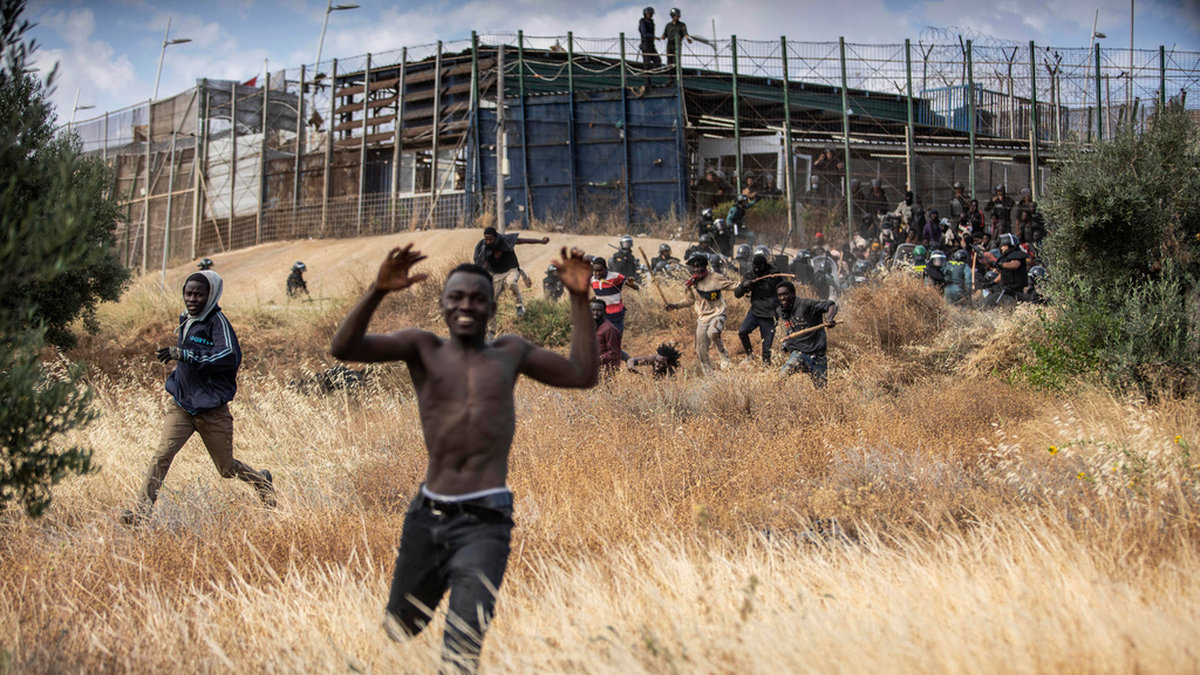 En man springer efter att ha korsat stängslet som skiljer Marocko och den spanska exklaven Melilla åt i juni.