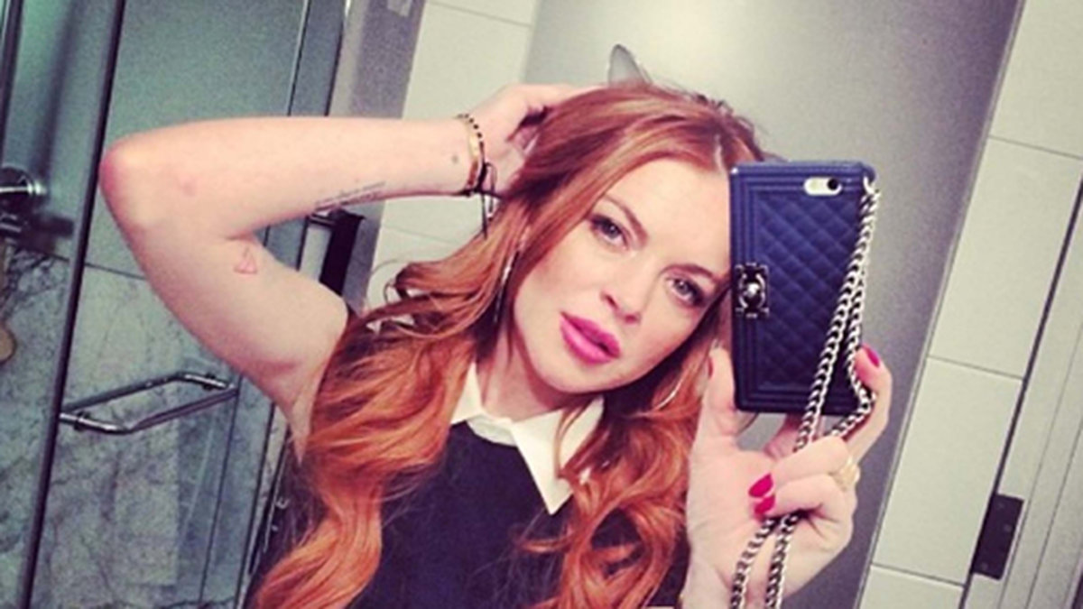 Lindsay Lohan visar oss sina rosa festsminkade läppar.