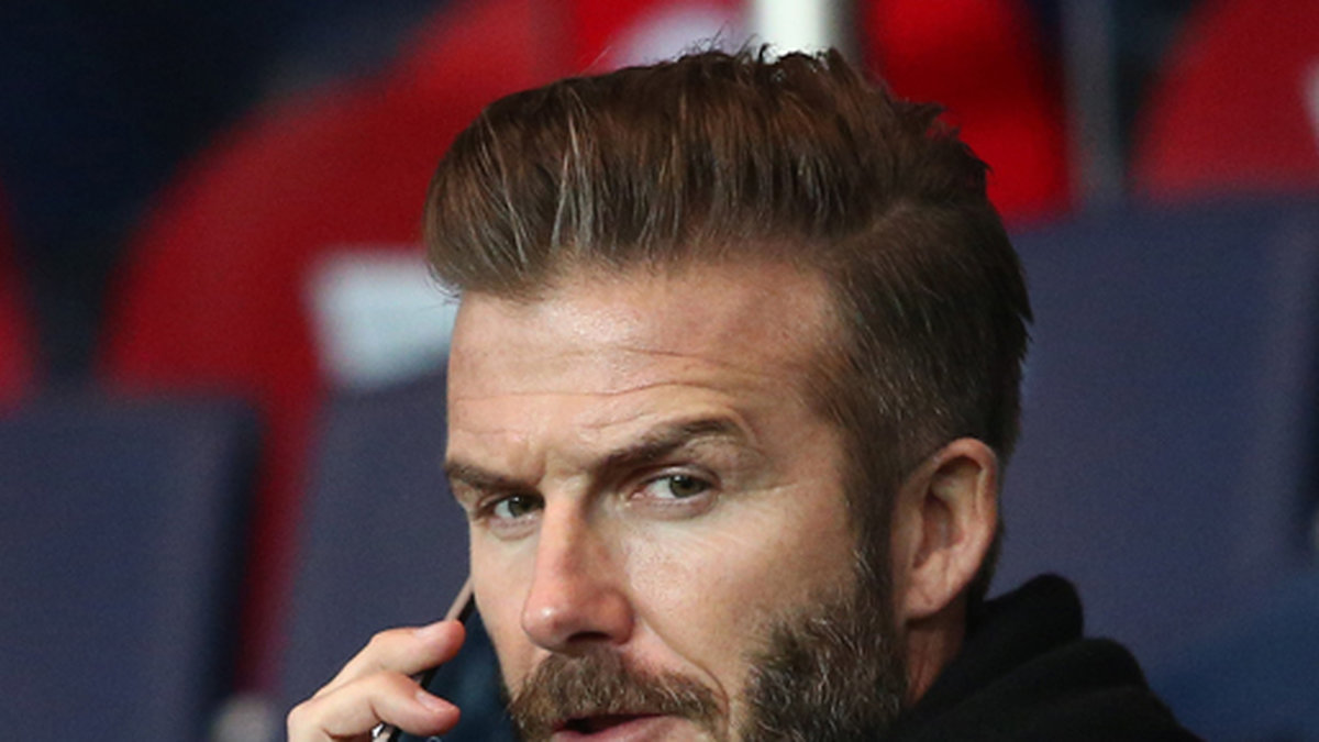 David Beckham snackar i mobilen när Paris Saint Germain möter Chelsea FC.