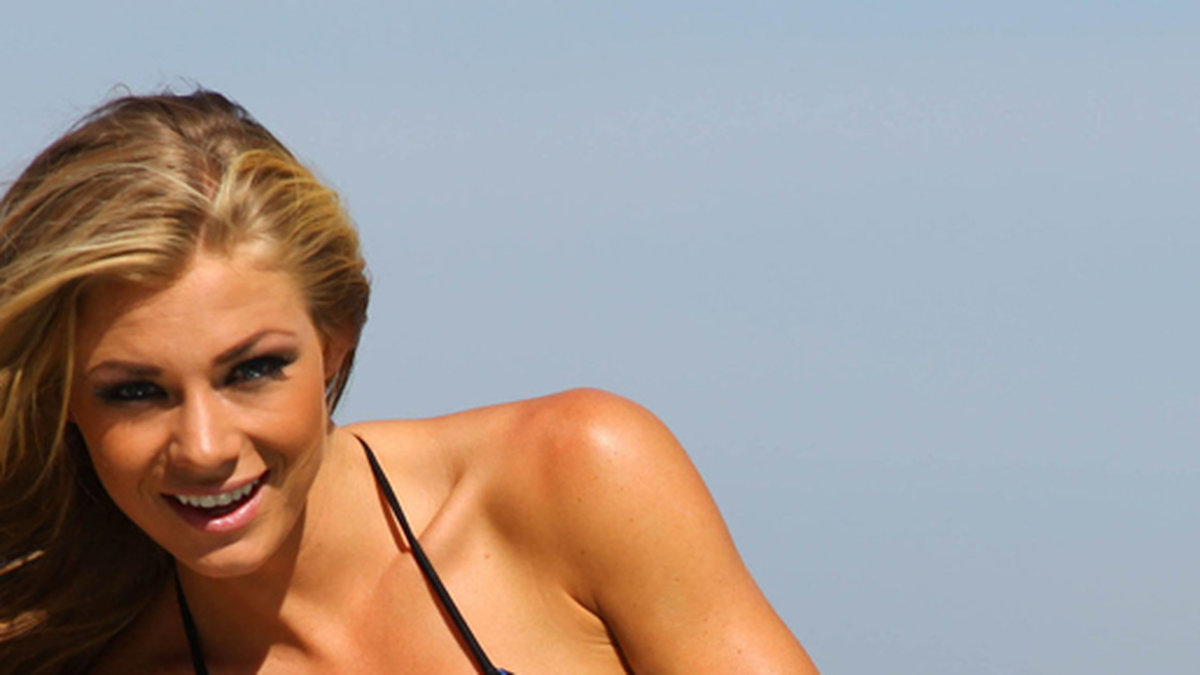 Playboymodellen Nikki Leigh poserar i bikinis vid poolkanten.