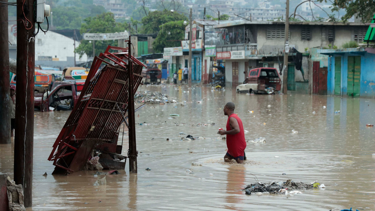 En man vadar genom vattenmassorna på de översvämmade gatorna i Port-au-Prince, Haiti.