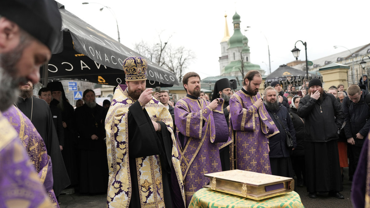 Präster inom den ukrainska ortodoxa kyrkan ber och visar sitt stöd till metropolit Pavel utanför klostret Petjerska i Kiev.