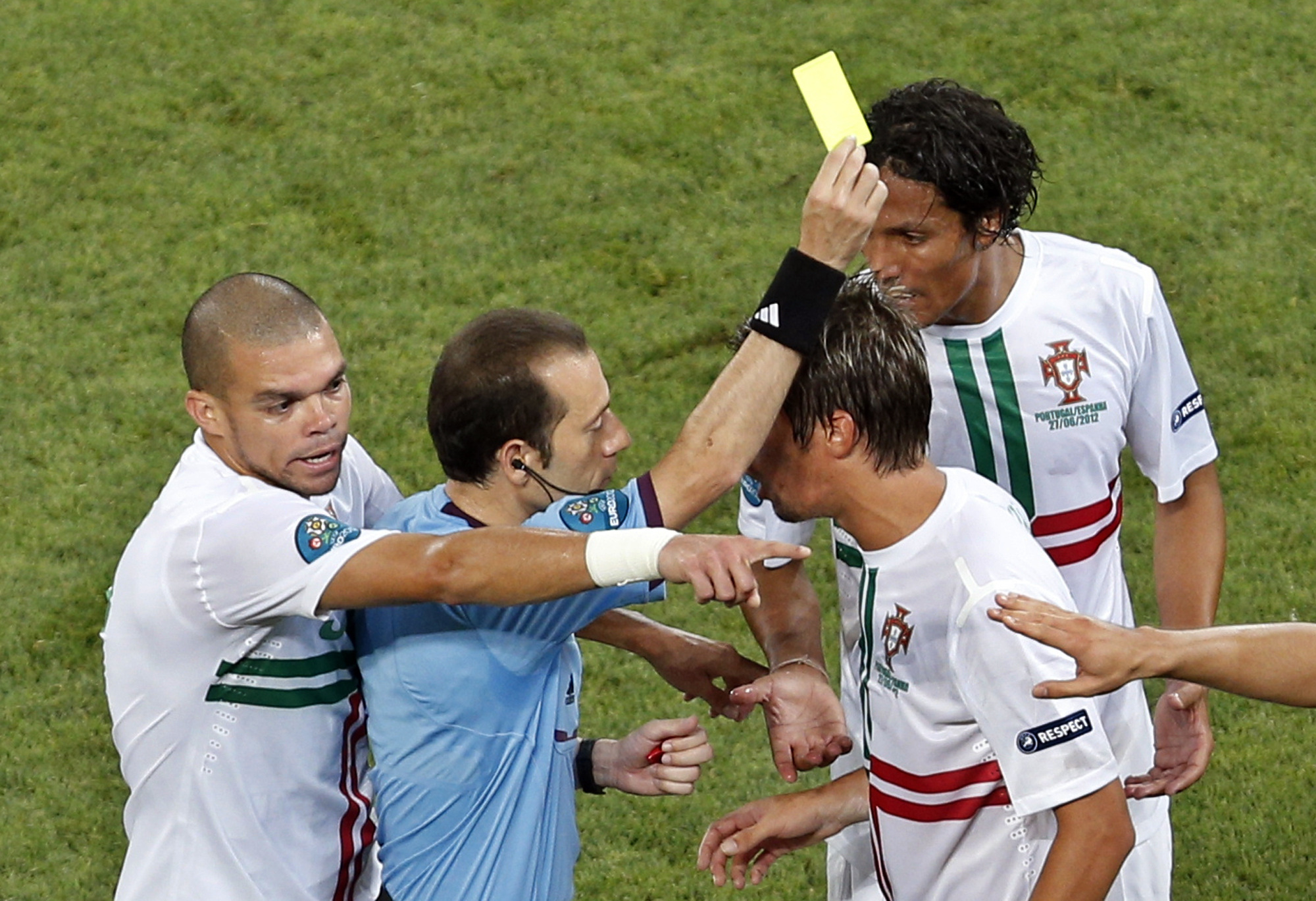 Domaren Cuneyt Cakir varnar Fabio Coentrao samtidigt som Pepe och Bruno Alves vill säga sitt.