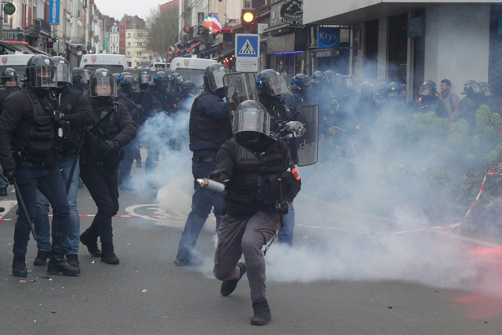 En polis förbereder sig för att kasta en tårgas under demonstrationen i Lille.