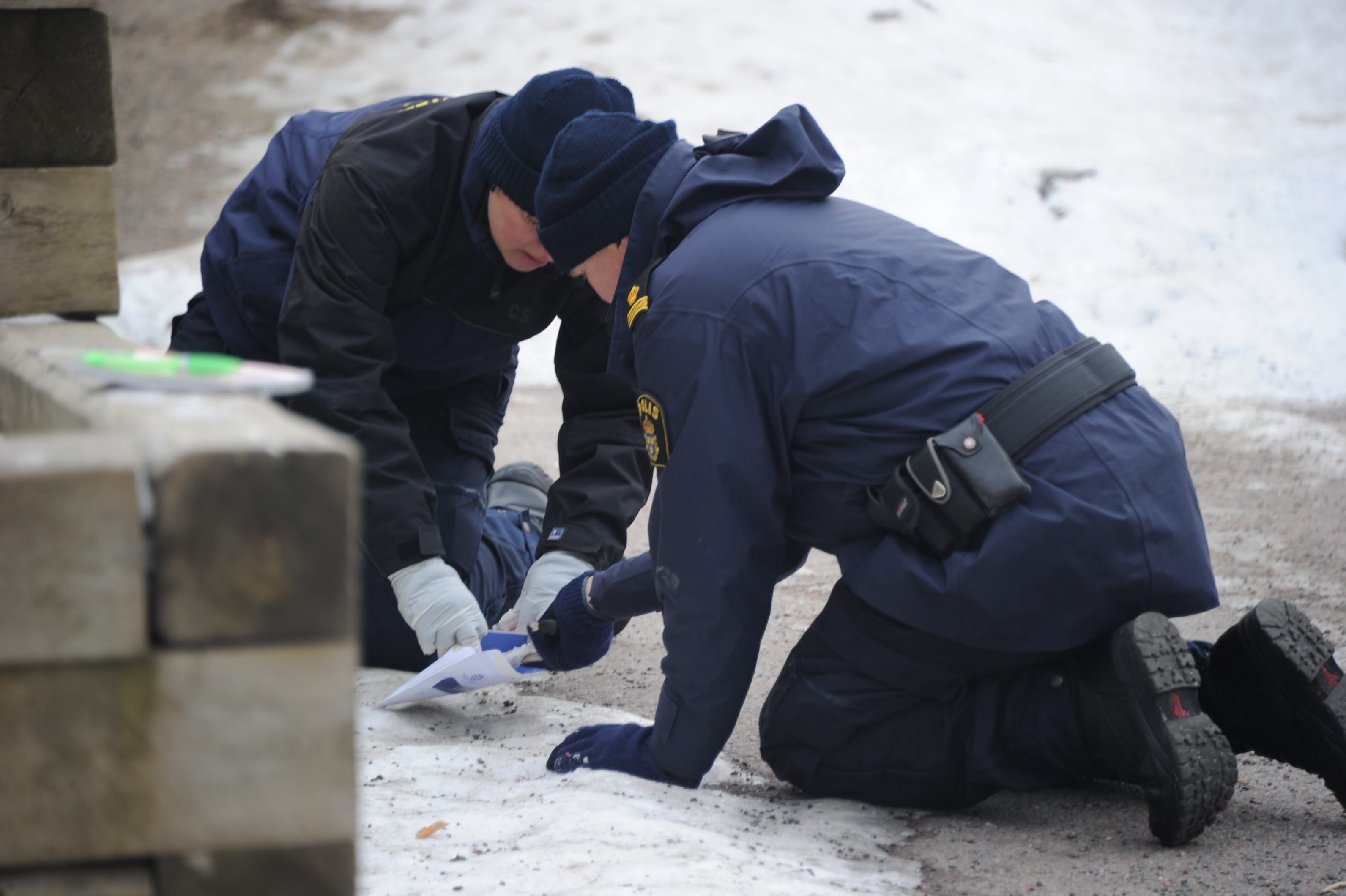 Polisen tekniker undersöker platsen för knivdådet. 