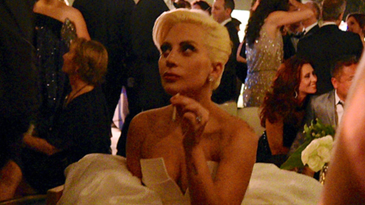 Lady Gaga tar en cigg och en drink på Emmy-galans efterfest. 