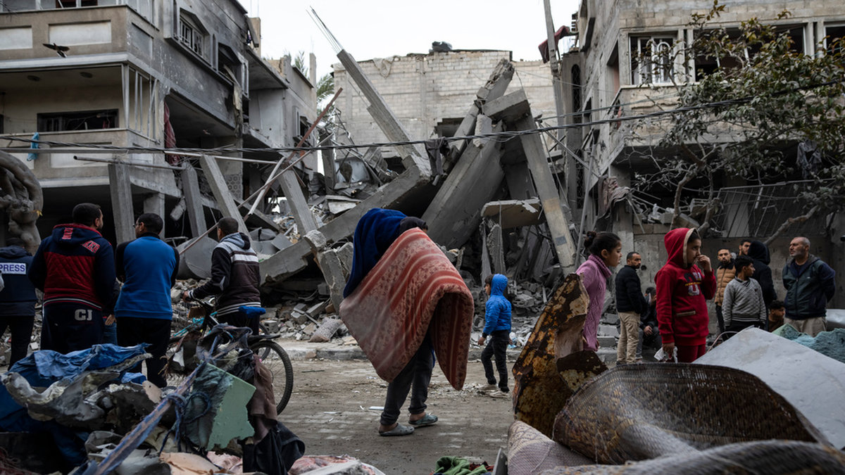 Palestinier betraktar förödelsen efter en israelisk attack mot ett bostadshus i Rafah i södra Gazaremsan.