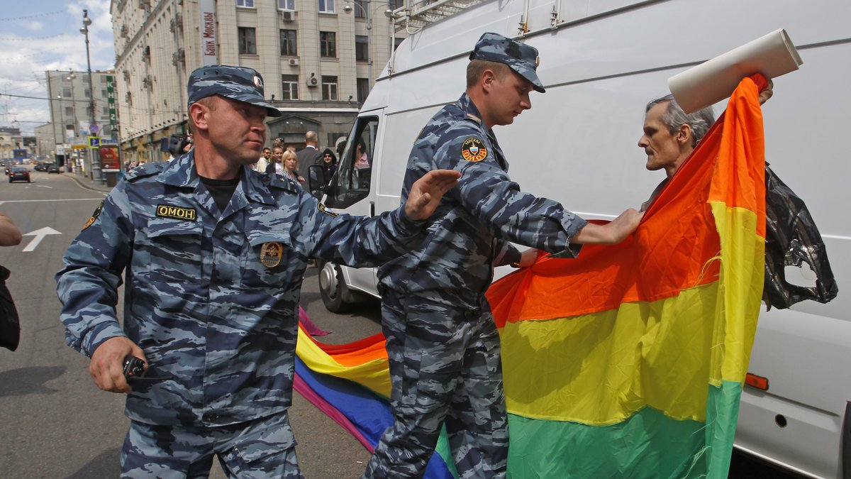 Polisen beslagtar regnbågsflagga.