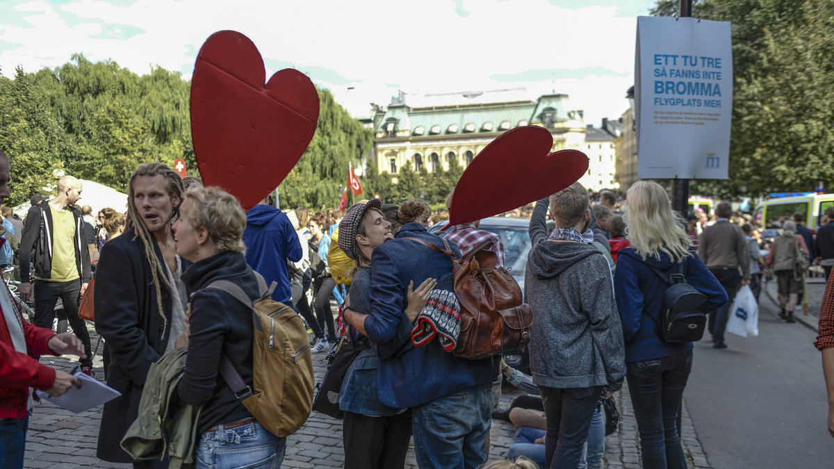 Motdemonstranter med hjärtskyltar i Kungsträdgården inför demonstrationen av nazistiska Svenskarnas Parti.