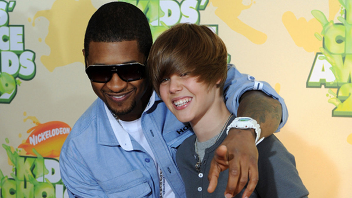 Justin syns knappt under luggen. Här med Usher år 2009.