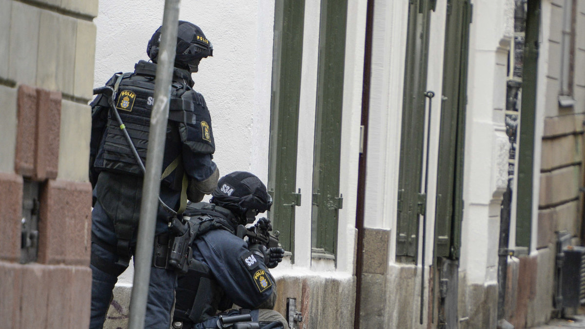 Beväpnad polis i gathörnen mot Stora Nygatan vid människorättsorganisationen Civil Rights Defenders i Gamla stan.