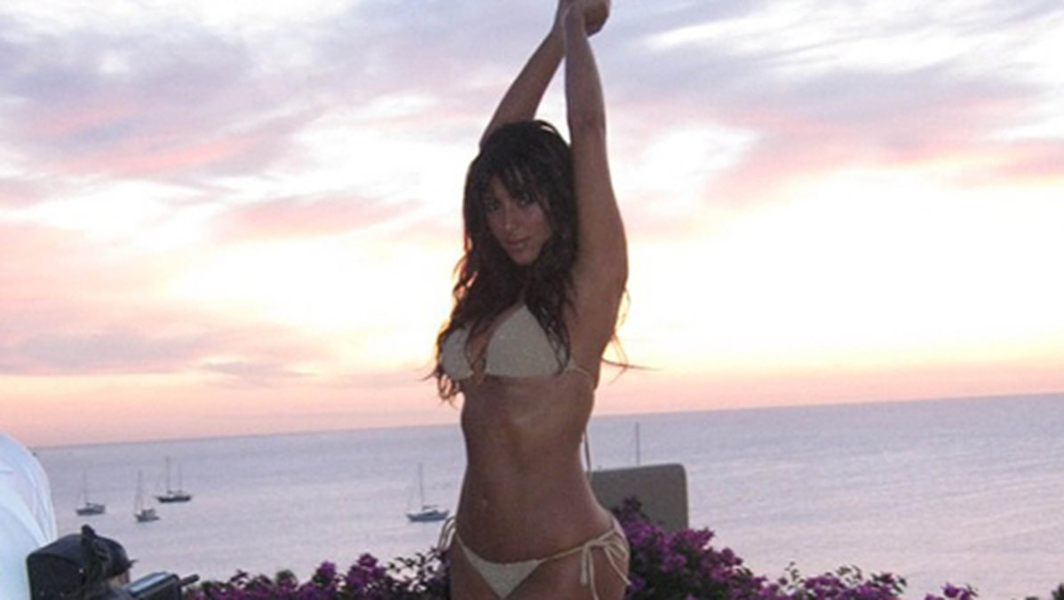 Kim Kardashian flexar sina muskler på stranden. 