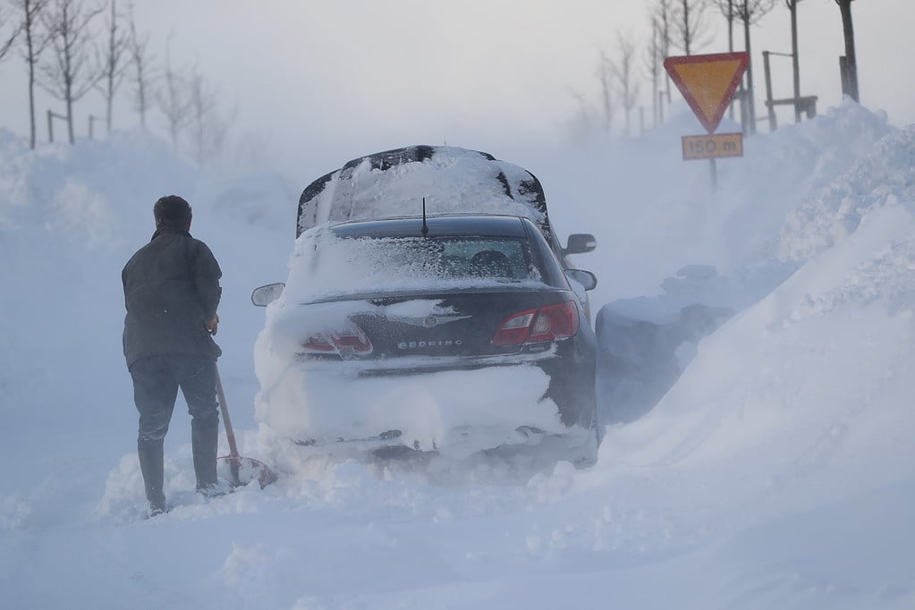 Skottar snö runt sin bil i Malmö i februari 2018 Skottar snö runt sin bil i Malmö i februari 2018