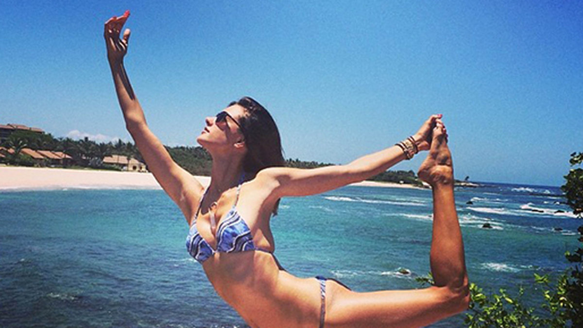 Alessandra Ambrosio gör yoga på stranden. 