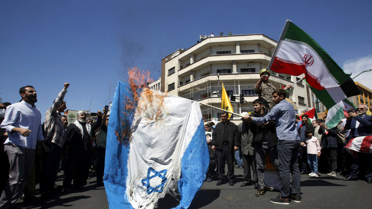 Iranska demonstranter bränner en israelisk flagga i samband med en begravningsprocession för de revolutionsgardister som dödades i Damaskus i förra veckan. Bild från Teheran den 5 april.