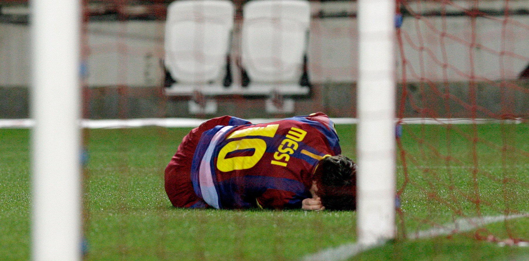 Lionel Messi ligger och vrider sig i smärtor under söndagens match mot Sevilla.