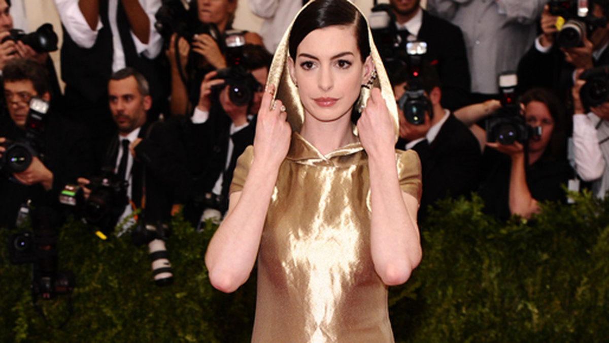 Anne Hathaway utmanade sin inre Rödluvan och vargen i en oformlig guldblåsa med luva. 