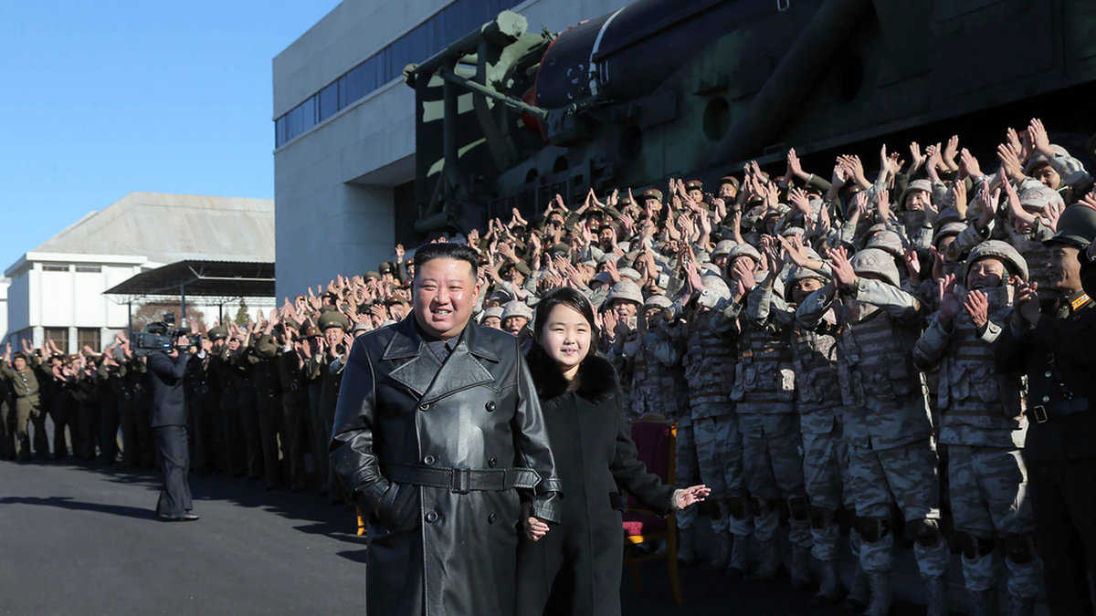 Kim Jong-Un och dottern Ju-Ae tillsammans med militärer som arbetar med robotprogrammet Hwasong-17. Bilden är odaterad, men publicerades på söndagen.