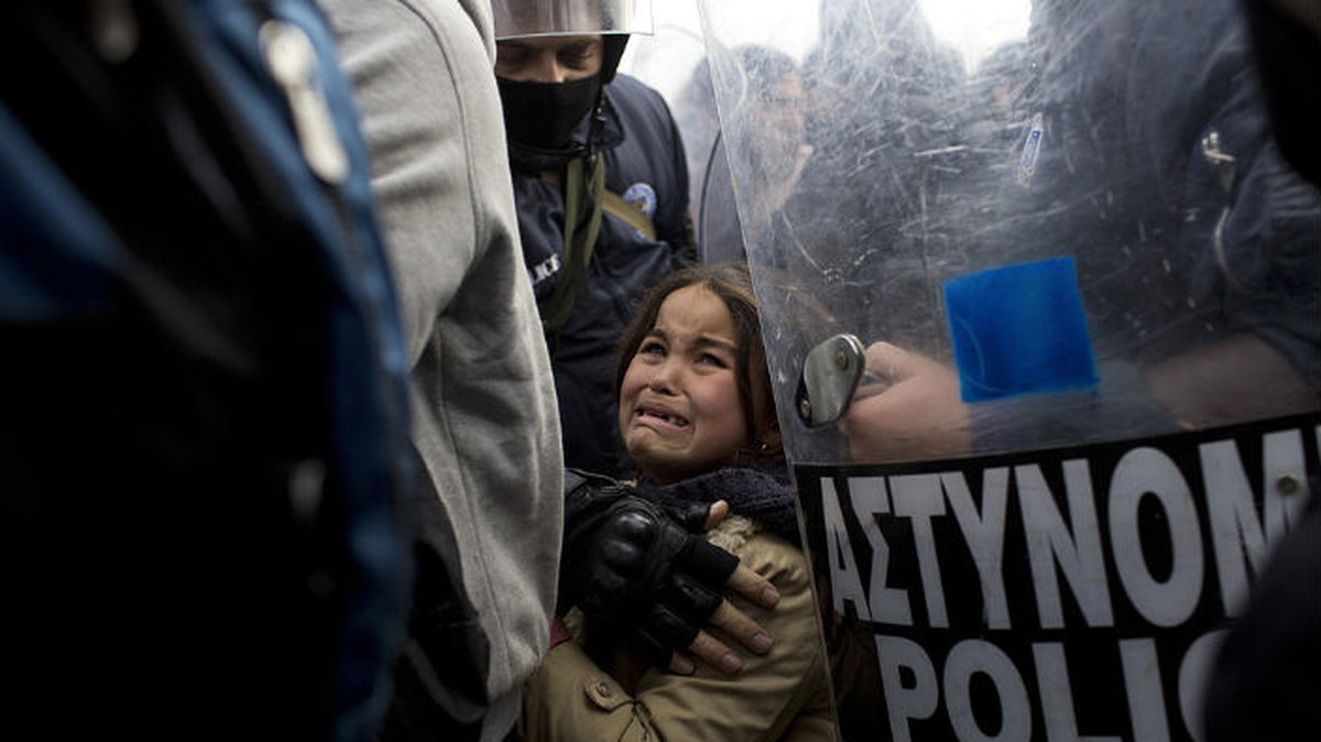 En flicka på flykt gråter förtvivlat vid den grekiska gränsen mot Makedonien i december 2015.