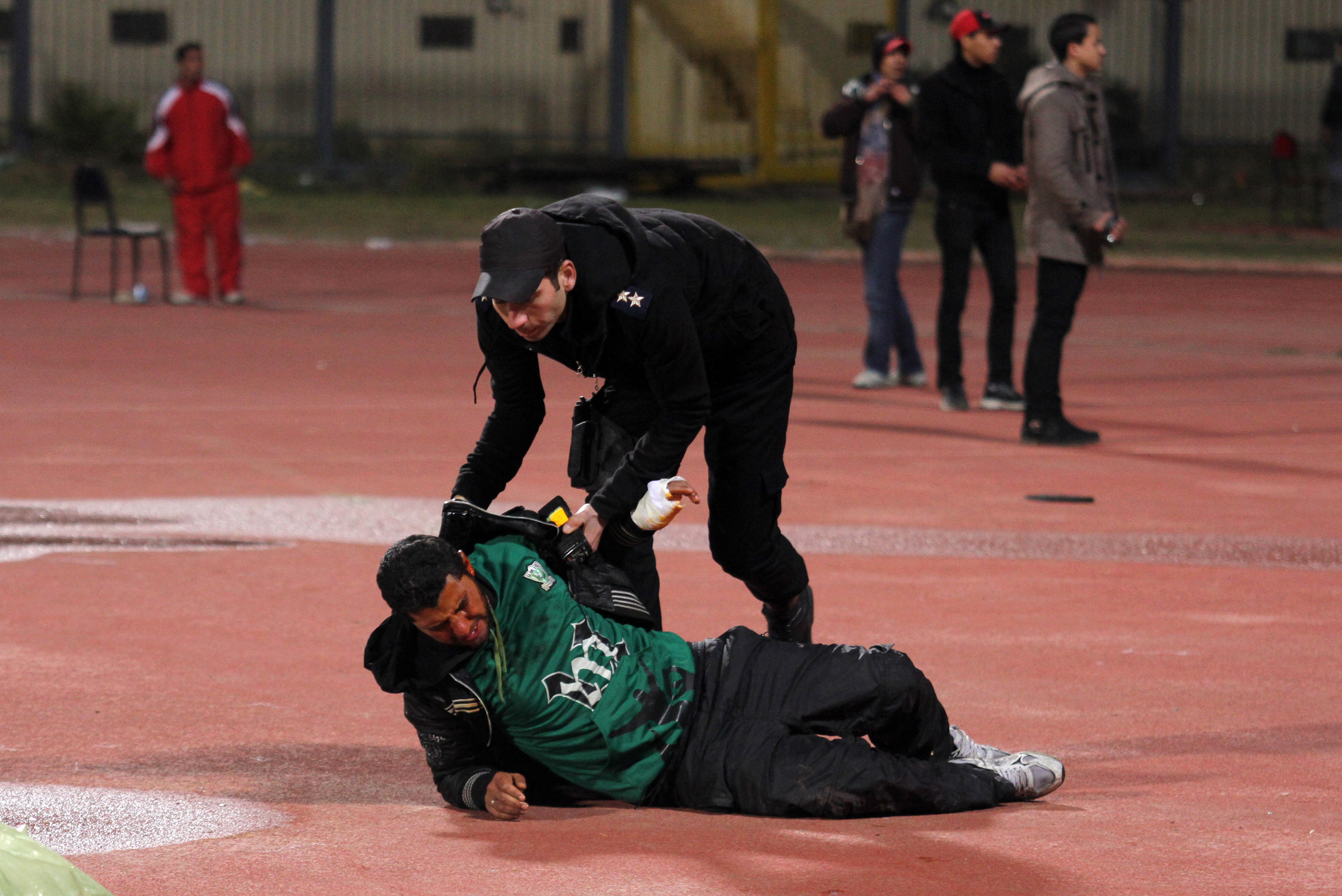 En polisman hjälper en skadad supporter.
