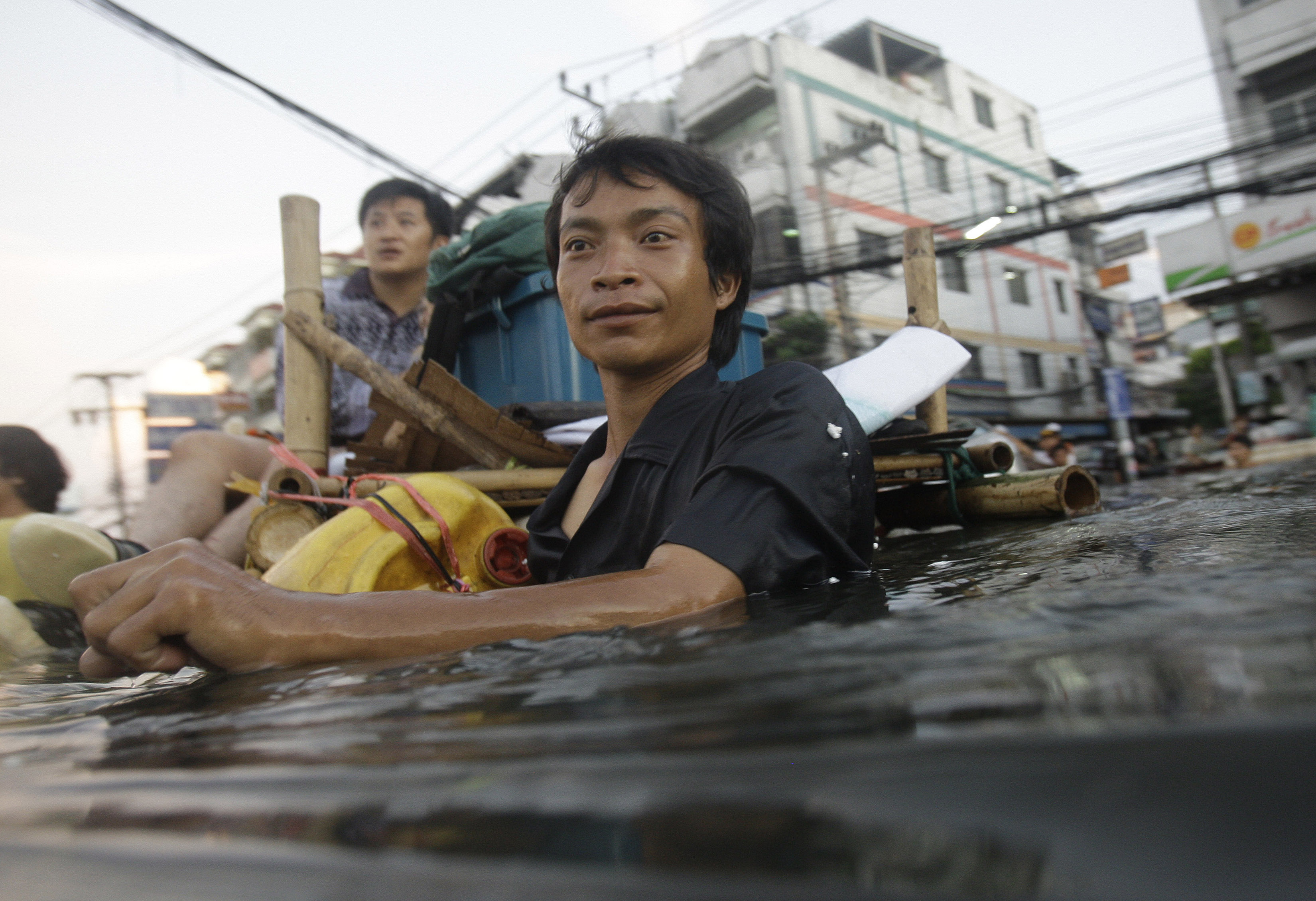 En försöker ta sig runt så gott det går i den översvämningsdrabbade thailändska huvudstaden. Nu avråder UD svenskar från att åka dit.