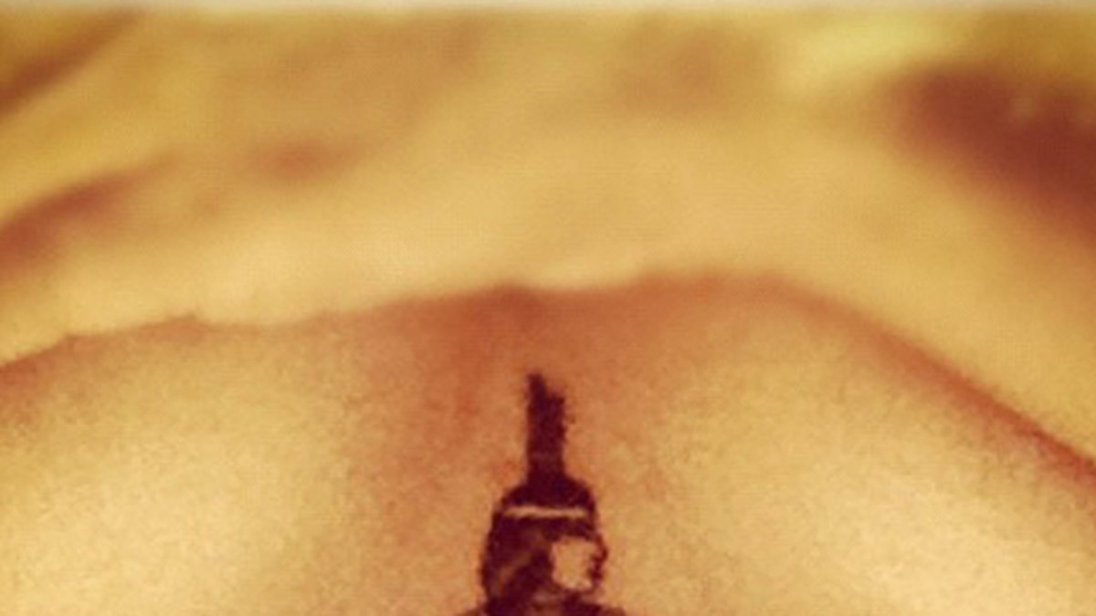 Rihanna visar sin tatuering under brösten. 