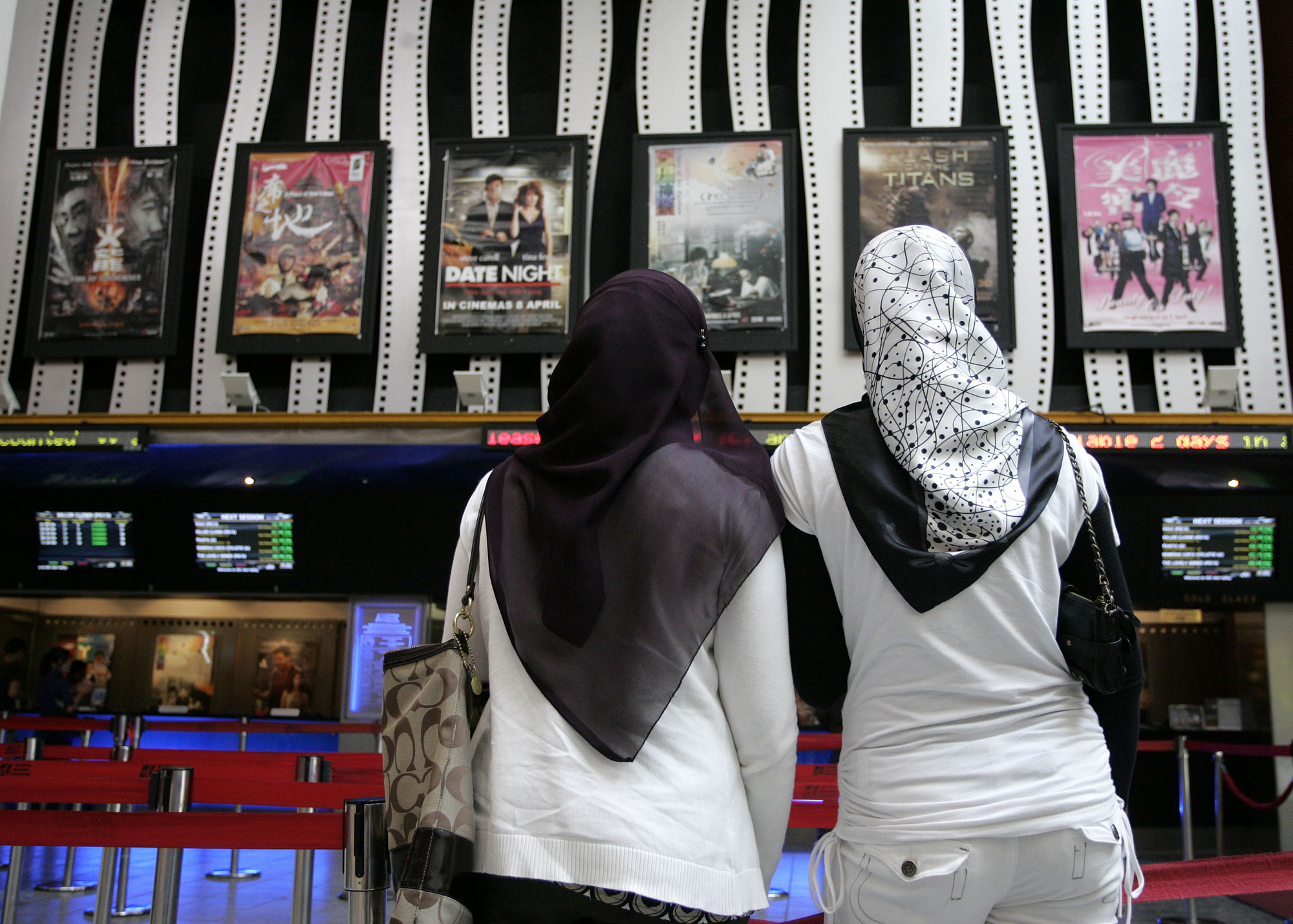 Två kvinnor tittar på affischer för den första gayrelaterade filmen någonsin i Malaysia, 2010.
